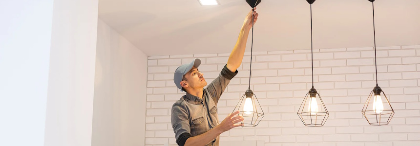 Electrician installing light fixtures